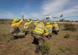 un retén de incendios junto al helicóptero de Medio Natural, en una imagen de archivo.