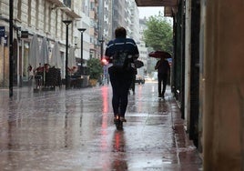 Varias personas transitan por la calle Calvo Sotelo de Logroño bajo la lluvia de este jueves.