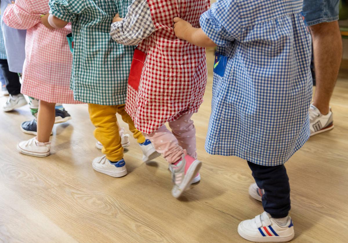 Varios niños hacen fila para entrar a un aula de Infantil.