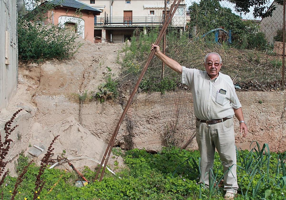 El afectado por la parálisis de las obras, Hilario Lerena, muestra los daños en su parcela, como la valla arrancada, escombros y metales.