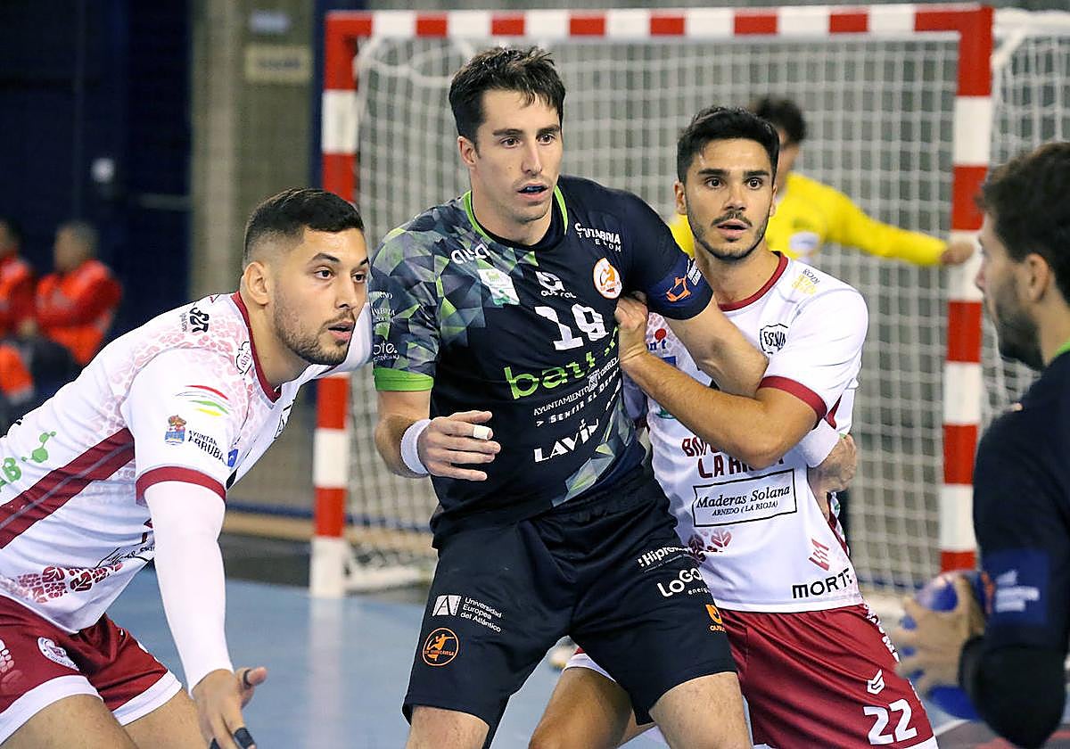 Xavi Tuà y El Korchi custodian al pivote del Torrelavega Borja Lombilla.