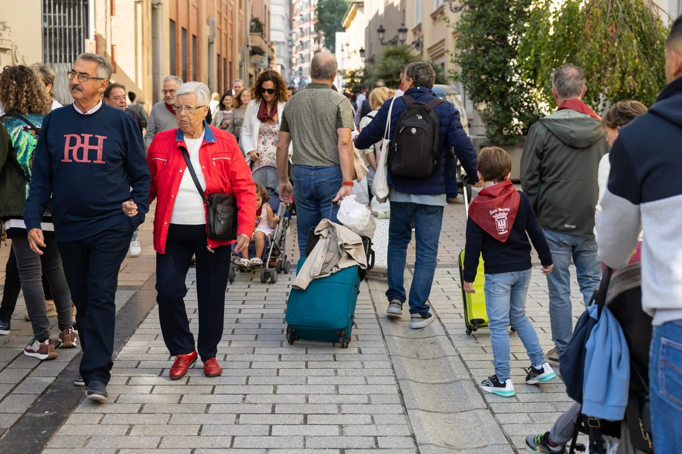 Visitantes con su maleta por la calle Portales.