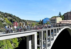 Los vecinos de Ortigosa de Cameros posan este domingo sobre el puente centenario para la foto de Antonio Tejero emulando la tomada por Alberto Muro en 1924.