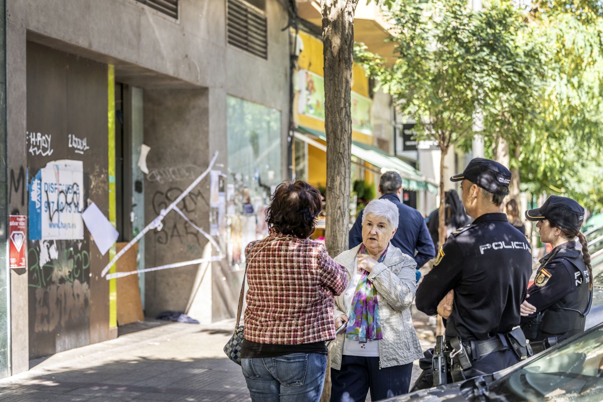 Vecinos y agentes policales junto al local precintado del 13 de la calle San Millán.