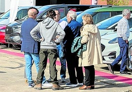 Una familia atiende las explicaciones de uno de los vendedores, en la zona exterior.