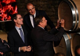 Rodolfo Bastida, director de la bodega; Gonzalo Capellán, presidente riojano, y Luis Planas, ministro, firmando una barrica.