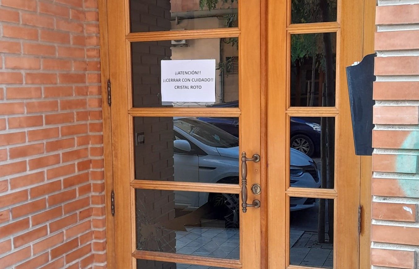 Portal con los daños producidos en el forcejeo y detalle del cristal roto.