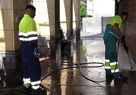 Dos operarios limpian los portales de la calle Grande en una campaña de refuerzo de la limpieza de la ciudad el año pasado.