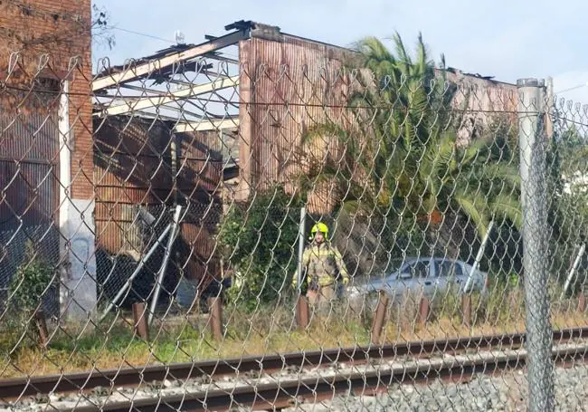 Un bombero, junto a la nave, una vez apagado el fuego.