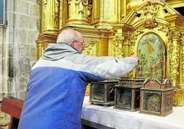 Javier Pangua coloca las cajas con los cráneos ubicadas a los pies de la imagen de la santa.