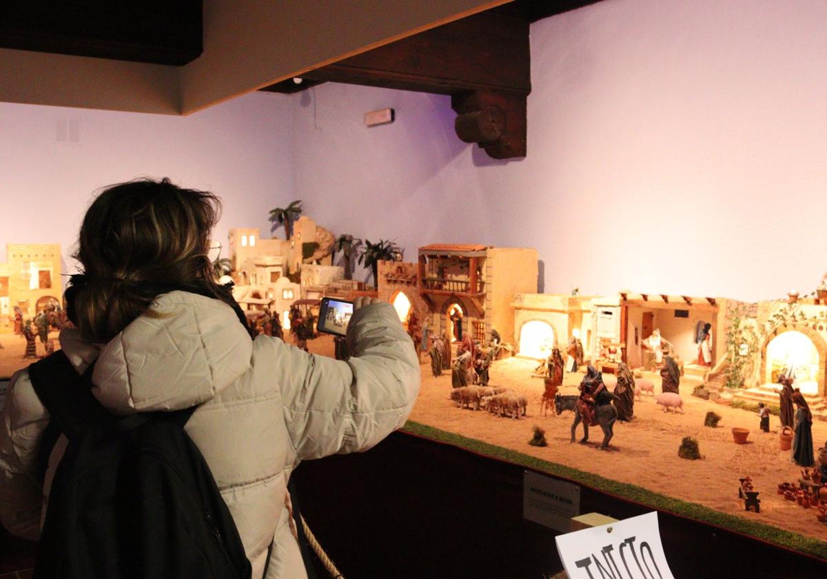 Una mujer fotografía una de las escenas del belén ubicado en el Palacio de los Condes de Haro.