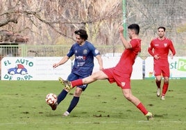 Barace, el artífice del primer gol, pega con la punta al balón para zafarse de la presión del Izarra sobre el blando verde de Isla.