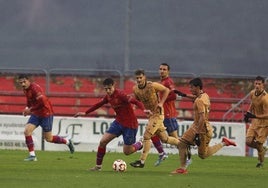 David Sánchez avanza con el esférico perseguido por dos jugadores del Eibar B.