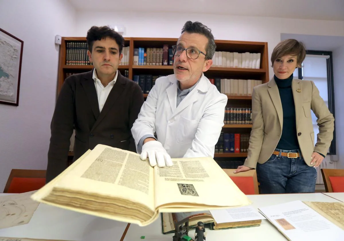 Ignacio Peso muestra la última adquisición de la biblioteca del IER, un libro impreso por Guillen de Brocar, junto a Roberto Iturriaga y Penélope Ramírez.