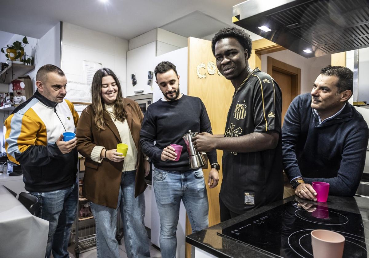 El joven Cheick Ouatlara, en uno de los pisos de Fundación Diagrama, sirve un café a algunos de los responsables de la entidad social que trabaja en la comunidad con el colectivo de menores: Óscar Hernández, Marta Suárez, Mario Ortega y Javier Martínez.