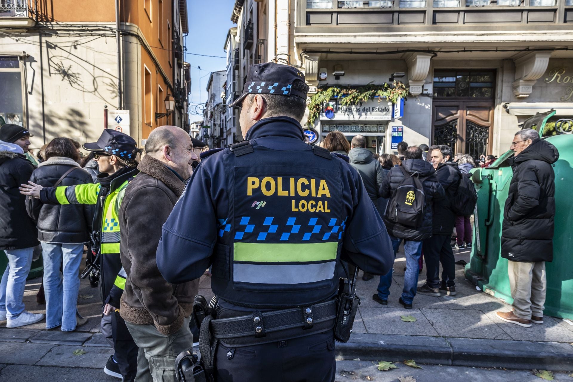 La Policía Local vigilando la zona de la administración de lotería donde se ha congregado numeroso público.