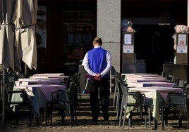 Un camarero prepara una terraza.