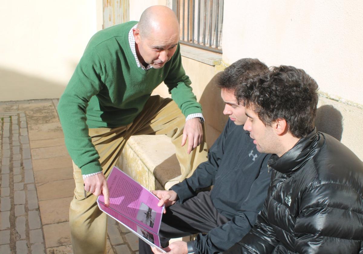 Varios vecinos de San Millán, adultos y jóvenes, hojean la recién publicada revista en un banco de la plaza de Tarsicio Lejárraga.