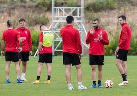 Bobadilla (dcha.) observa como Lupu (centro) charla con un compañero en un entrenamiento.