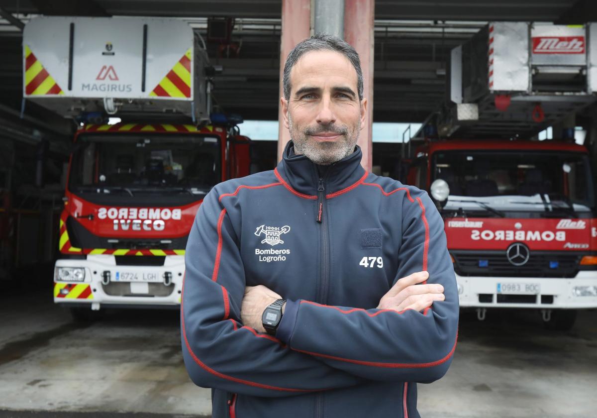Daniel León, delante de dos camiones en el Parque de Bomberos de Logroño.