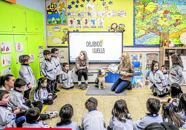 María Cegarra y Noelia Higes, con el perro Epi en medio, durante una sesión en tercero de Infantil en el colegio Agustinas de Logroño.