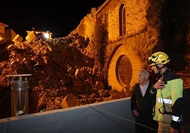 Florencio, vecino de la zona, habla con un bombero frente al derrumbe.