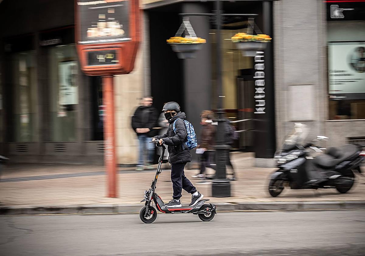 Un hombre circula con un patinete por el centro de Logroño.