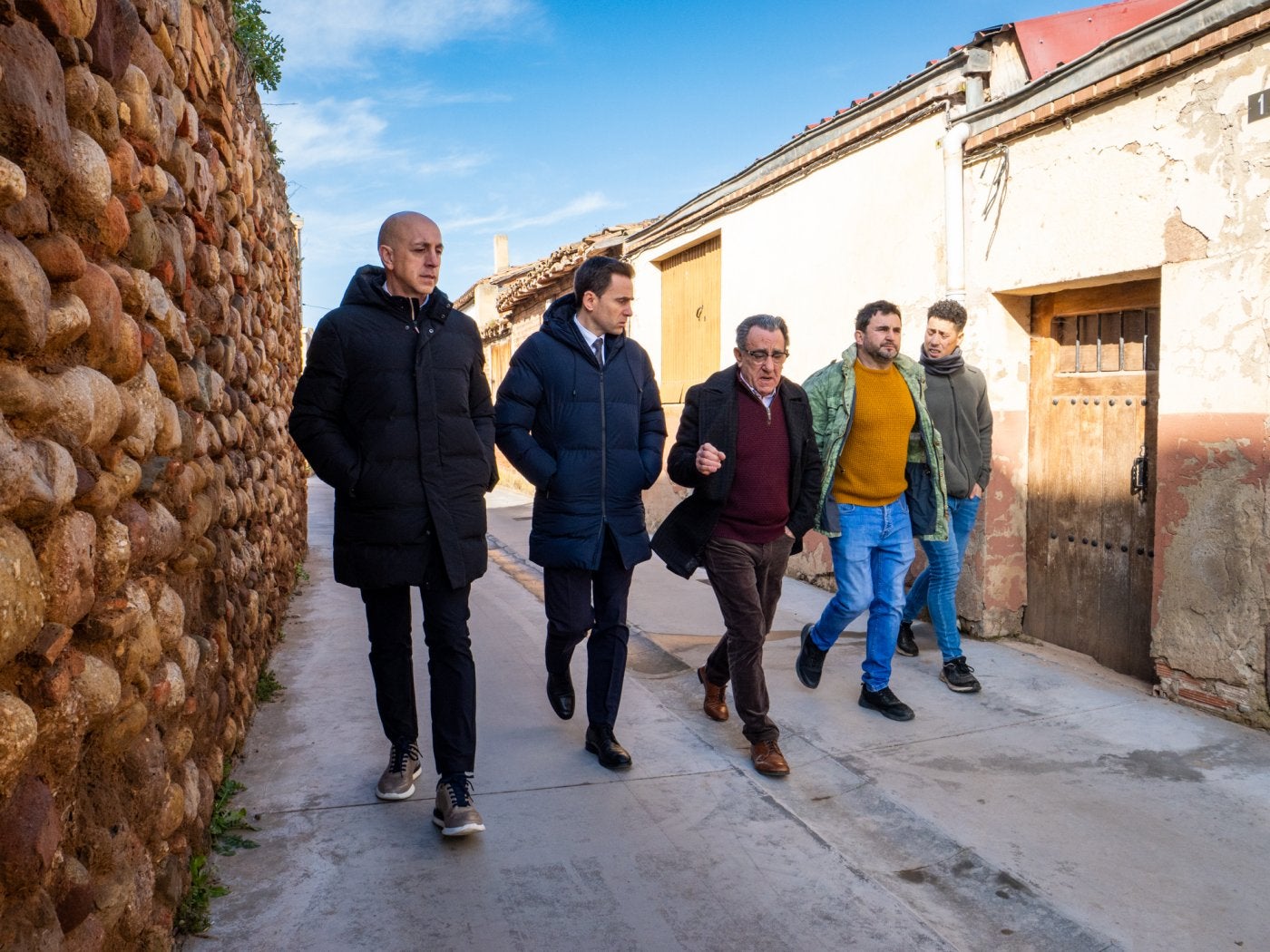 Varios políticos, con el alcalde en el centro, pasean por el pueblo.