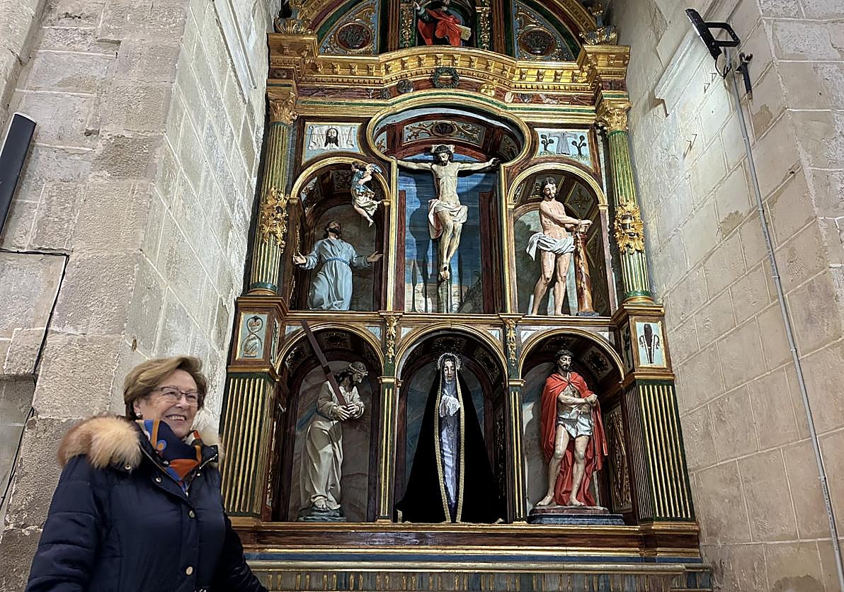 Lucía Zárate, vecina de la localidad, delante del retablo restaurado de la iglesia de San Miguel de Foncea.