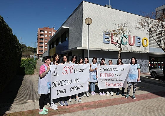 Las educadoras de El Cubo, con dos pancartas en la que muestran su malestar.