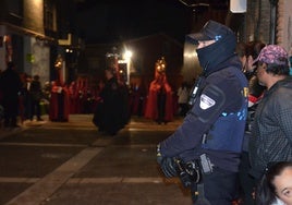 Un agente, con chaleco antibalas y arma, custodiando una procesión el año pasado.