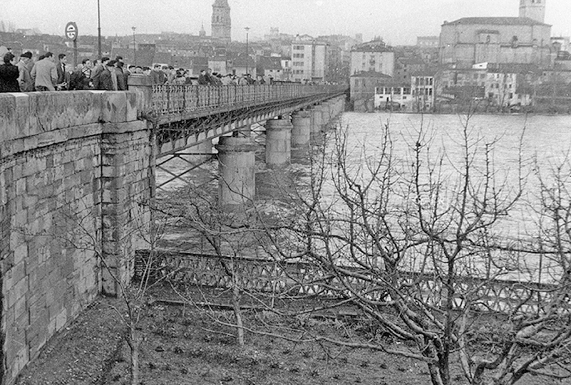 Ciudadanos observan la crecida del río Ebro desde el Puente de Hierro en 1958.