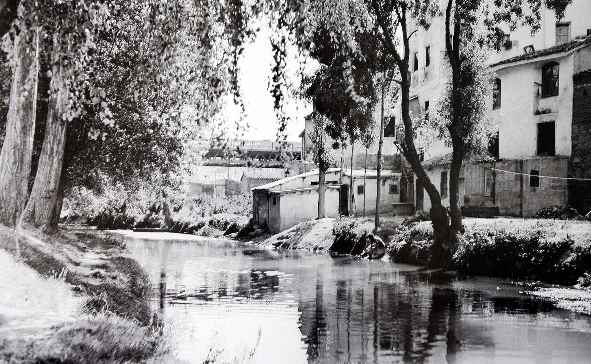 'Ebro Chiquito' con el Puente de Hierro al fondo y construcciones de entonces con una lavandera completando el conjunto.