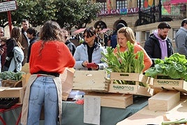 Visitantes, en uno de los puestos del mercado celebrado en abril.