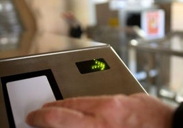 Un trabajador ficha a la entrada a su puesto.