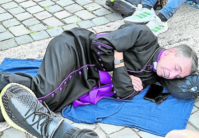 Un religioso descansa en plena calle, sobre los adoquines de la Plaza de San Pedro.