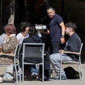 Un camarero atiende a un grupo de jóvenes sentados en una terraza en la plaza del Mercado, en Logroño.