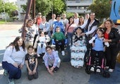 Varias familias de las comunidades educativas de los centros Marqués de Vallejo y Los Ángeles posan en el columpio adaptado de Los Lirios.