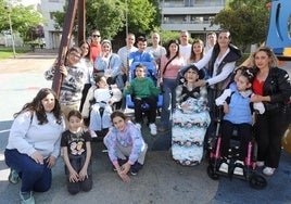Varias familias de las comunidades educativas de los centros Marqués de Vallejo y Los Ángeles posan en el columpio adaptado de Los Lirios.