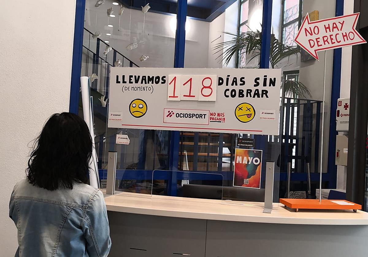 Una usuaria observa el contador de días sin cobrar que acumulan los trabajadores de La Gota de Leche.