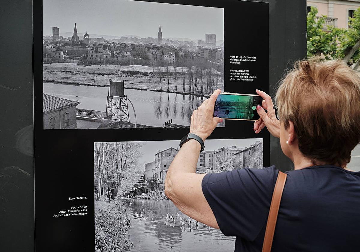 Una mujer saca su móvil para fotografiar una de las imágenes de la muestra.