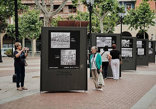 Varias mujeres observan las instantáneas de la muestra.