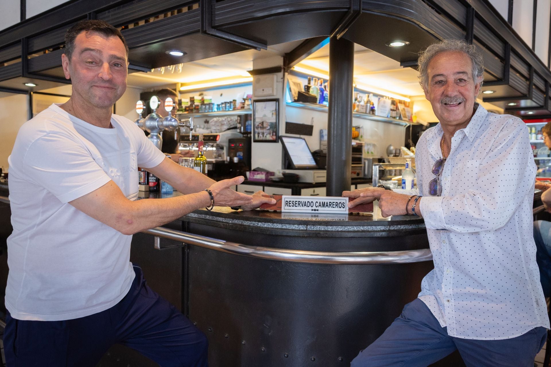 Víctor Manuel Riera y Francisco Martínez Bergés señalan la zona reservada a camareros del bar Ópera de Logroño.