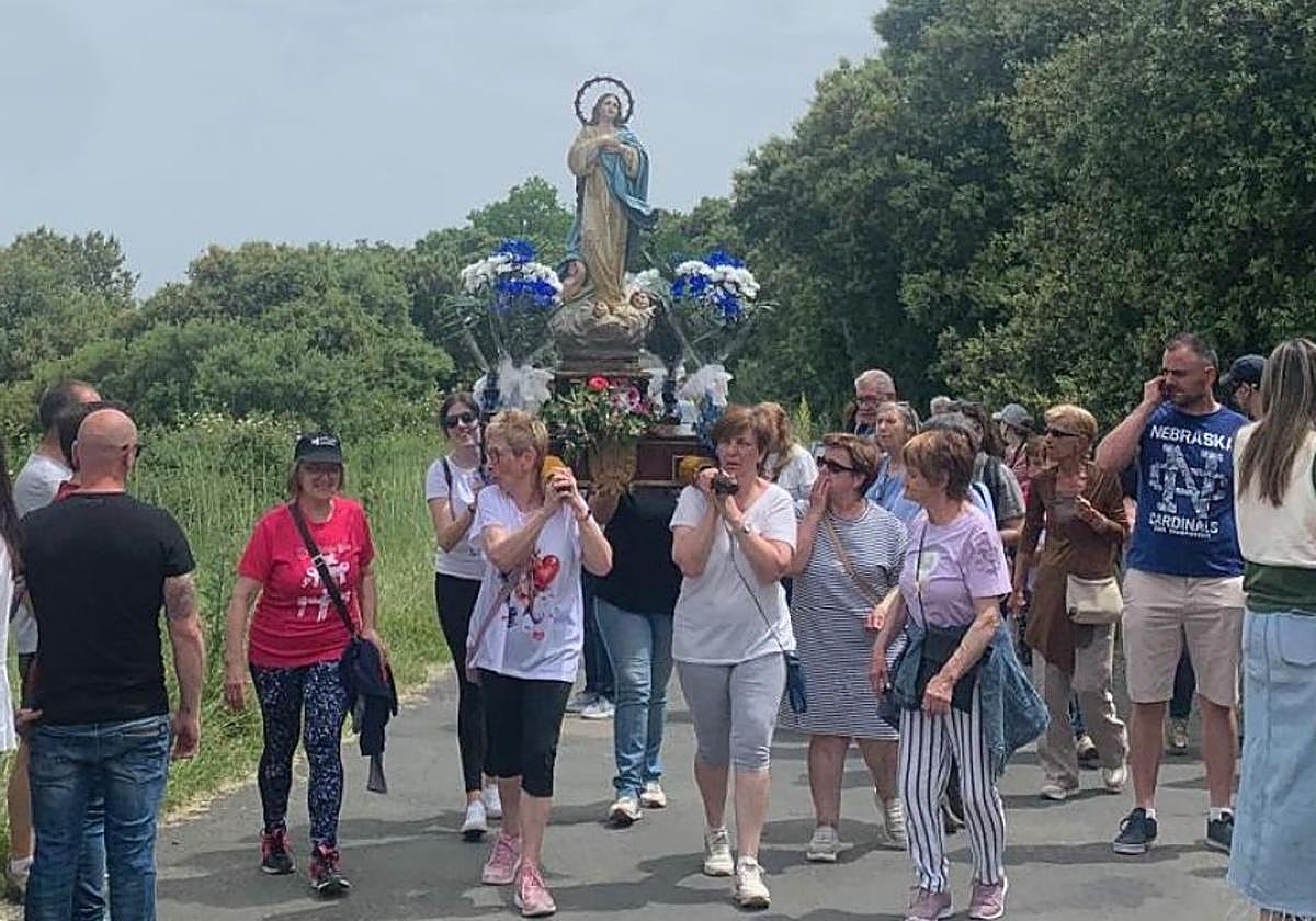 Un grupo de mujeres porta una imagen de la virgen.