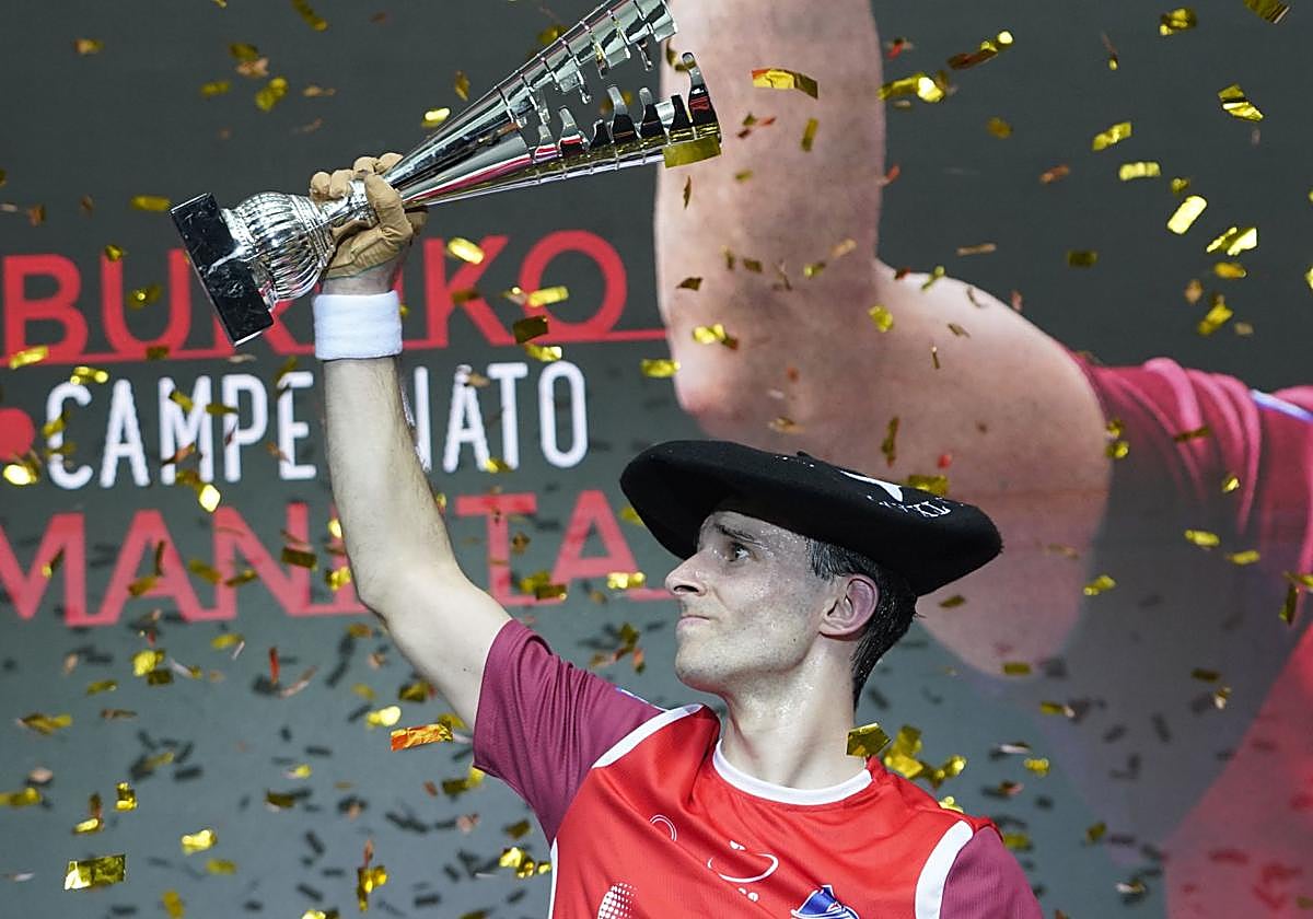Altuna celebra el triunfo en el Manomanista con la copa y la chapela de campeón.