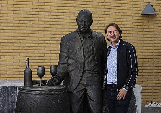 Santiago Vivanco posa junto a la estatua de su padre, Pedro, a la entrada del museo.