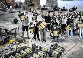 Alumnos de Obras de Interior del IES Batalla de Clavijo y el profesor Gonzalo Valiente sostienen las farolas de la instalación de Concéntrico con la que colaboran este año.