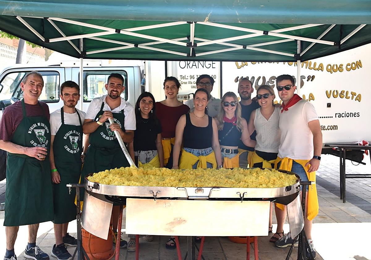 Varios peñistas, el alcalde y el concejal de festejos junto a la tortilla en preparación