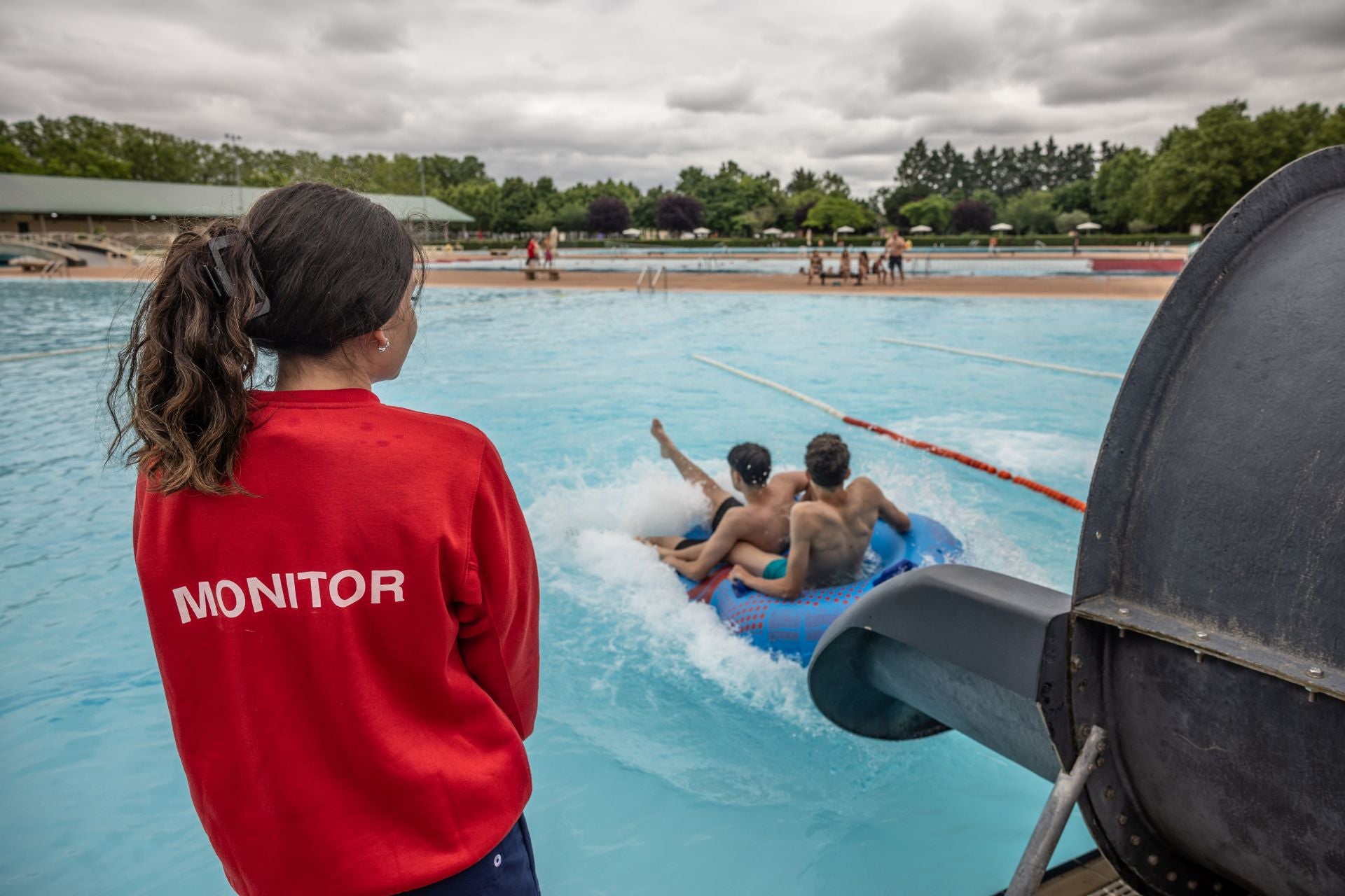 Una monitora, a pie de piscina, pendiente de los usuarios del tobogán en Las Norias.