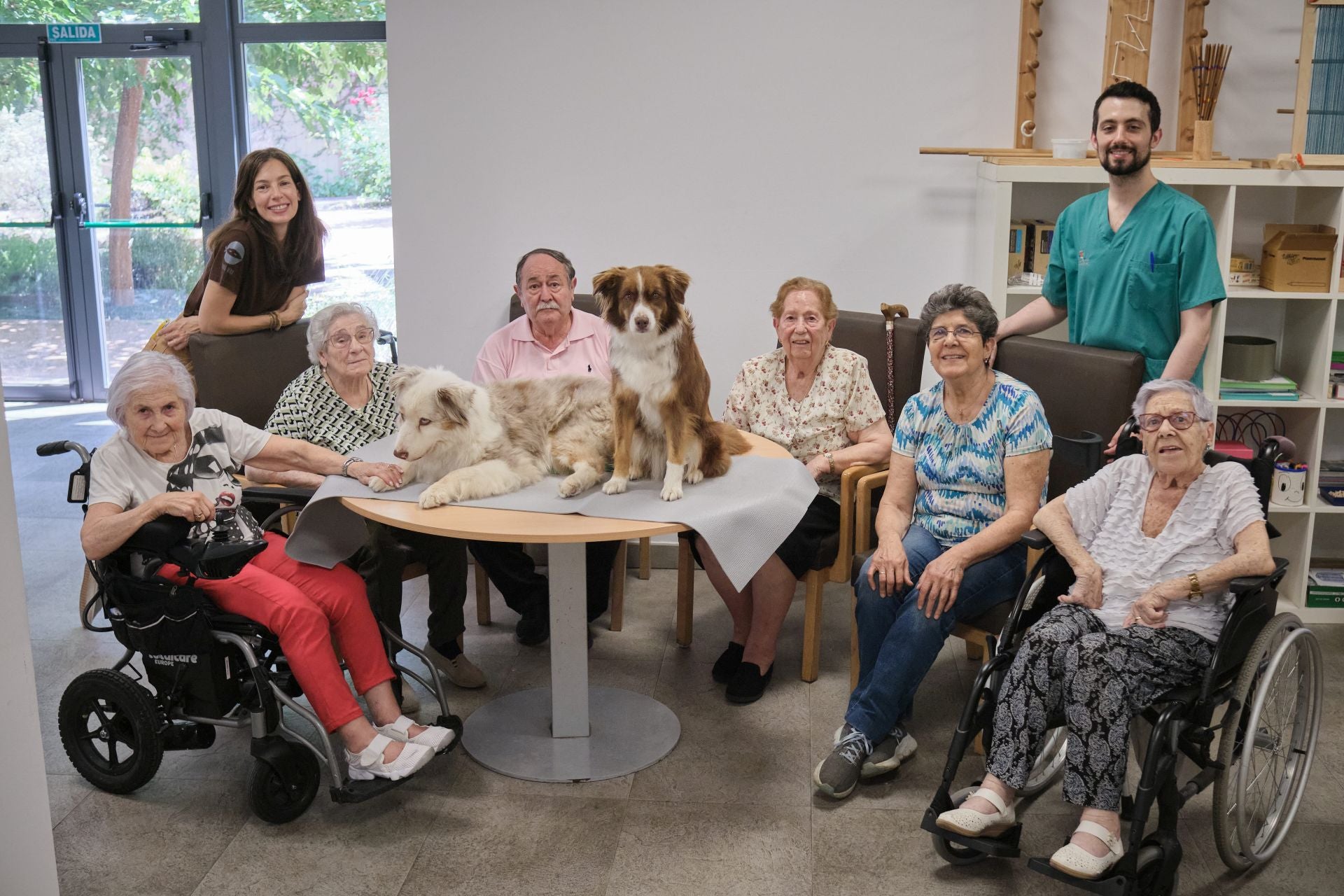 Ana Rodríguez e Israel Villada posan con los usuarios del centro de día Gonzalo de Berceo de Logroño y las perras Tirma y Poliki.